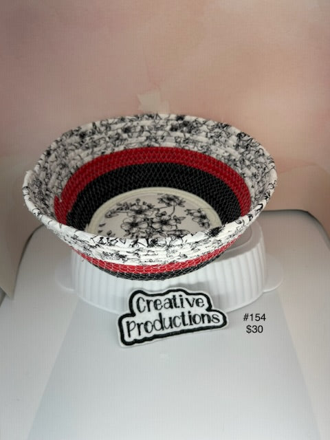 Rope basket with black and white floral design fabric insert and red and black accents